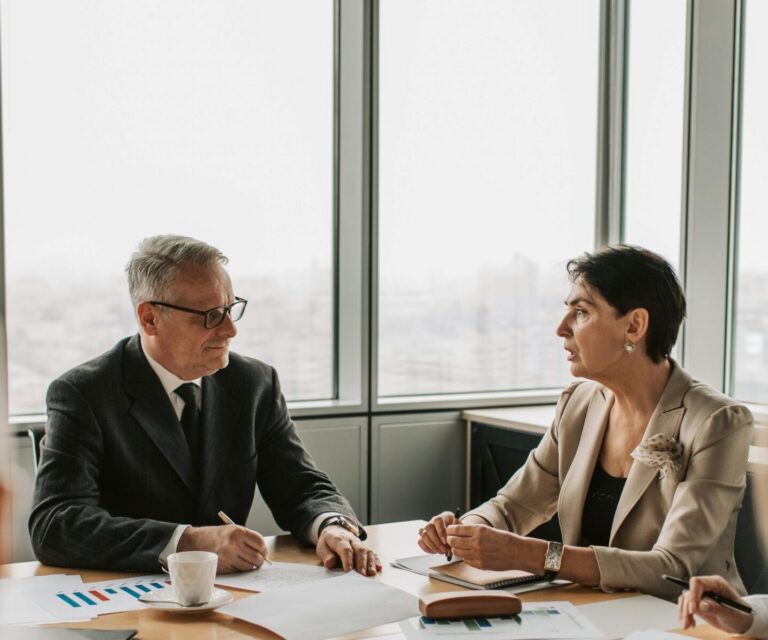 Executives in a board meeting reviewing documents at a conference table